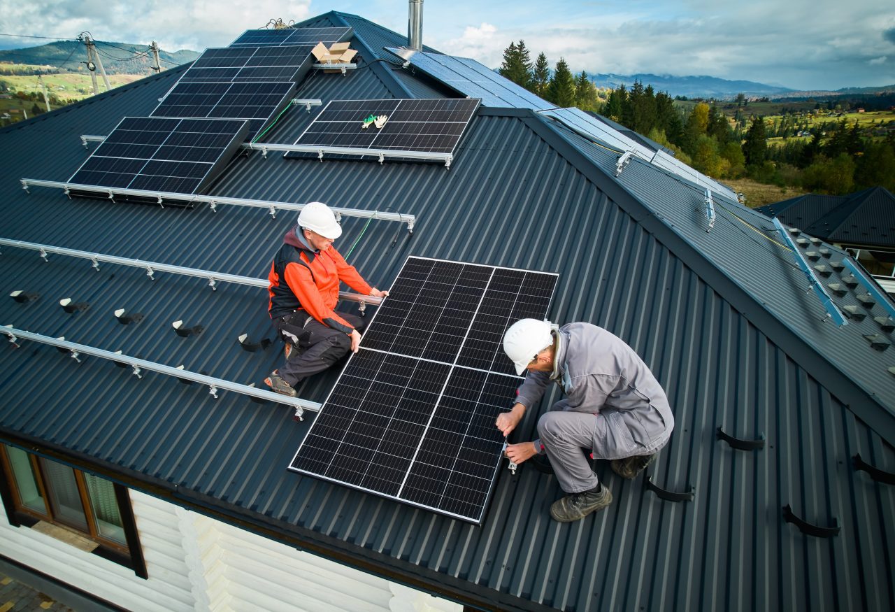 technicians-installing-photovoltaic-solar-panels-on-roof-of-house--e1696237312747.jpg